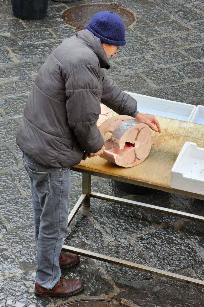Ćwiartowanie tuńczyka na targu rybnym w Katatnii.