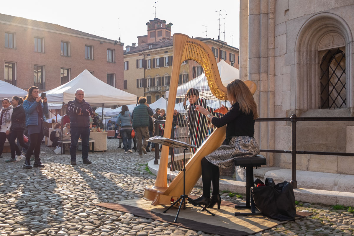 Co warto zobaczyć w Modenie? Harfistka na Piazza Grande.