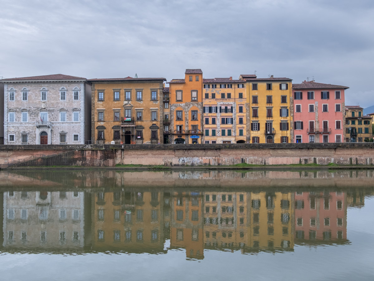 Kolorowe kamienice nad rzeką Arno w Pizie.